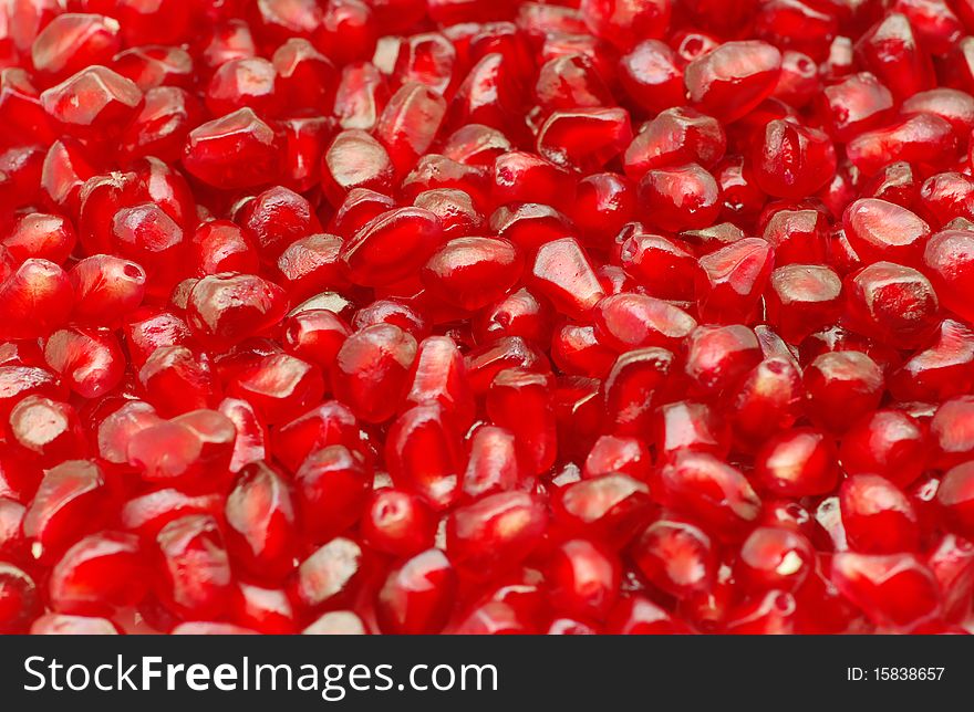 Macro of peeled ripe seeds pomegranate background