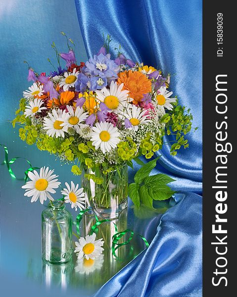 Bunch of flowers in a vase on a dark blue background. Bunch of flowers in a vase on a dark blue background