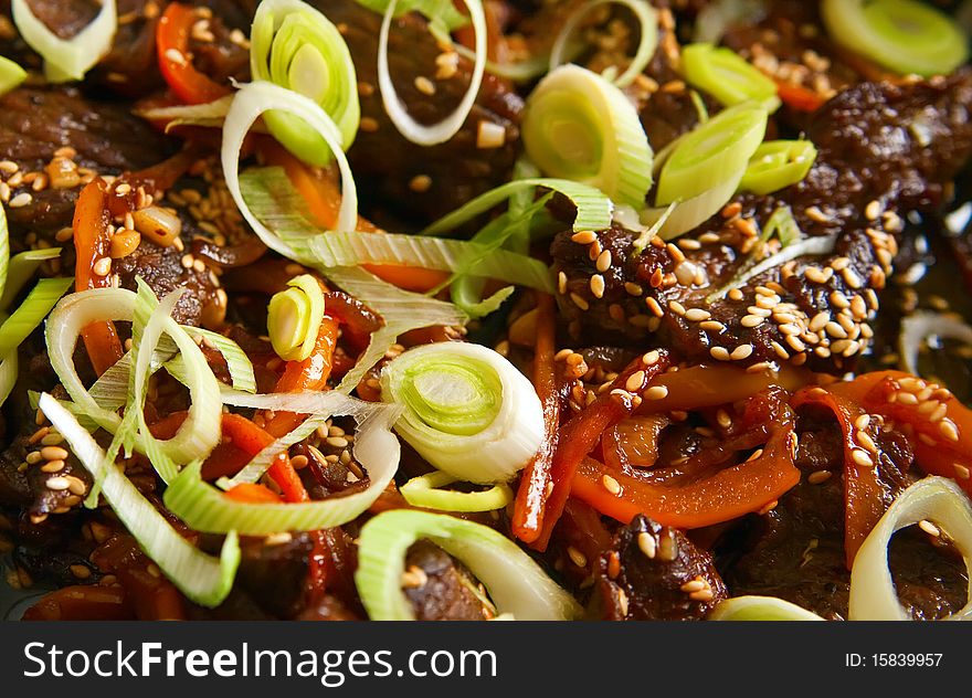 Close-up pan with sliced beef, sesame, paprika and and green leek, it is preparation of tasty dinner. Close-up pan with sliced beef, sesame, paprika and and green leek, it is preparation of tasty dinner