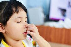 Asian Little Girl Sick With Hand Holding The Nose Get Cold And Blow Nose The Flu Season - Child Runny Nose And Sneezing Blowing Royalty Free Stock Photography Asian Little Girl Sick With Hand Holding The Nose Get Cold And Blow Nose The Flu Season - Child Runny Nose And Sneezing Blowing Royalty Free Stock Photography
