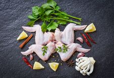 Raw Chicken Wings With Lemon Chilli Herbs And Spices And Mushroom On Black Plate  Top View - Raw Uncooked Chicken Meat Marinated Stock Photos