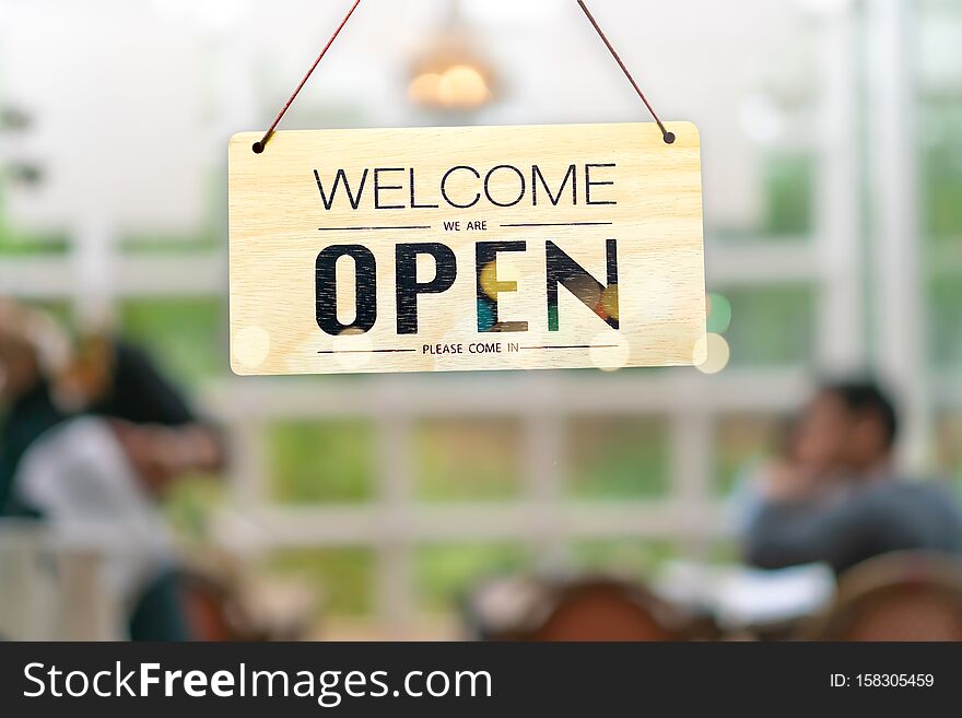 A business sign that says open on cafe or restaurant hang on door at entrance. Vintage color tone style