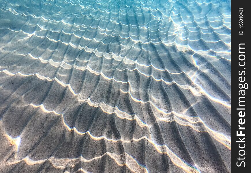 Clear water. underwater background with sandy sea bottom. Beautiful texture of the sea and ocean water