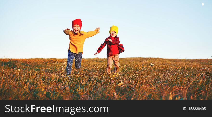 Happy kids   boy and girl running and laughing on autumn nature walk