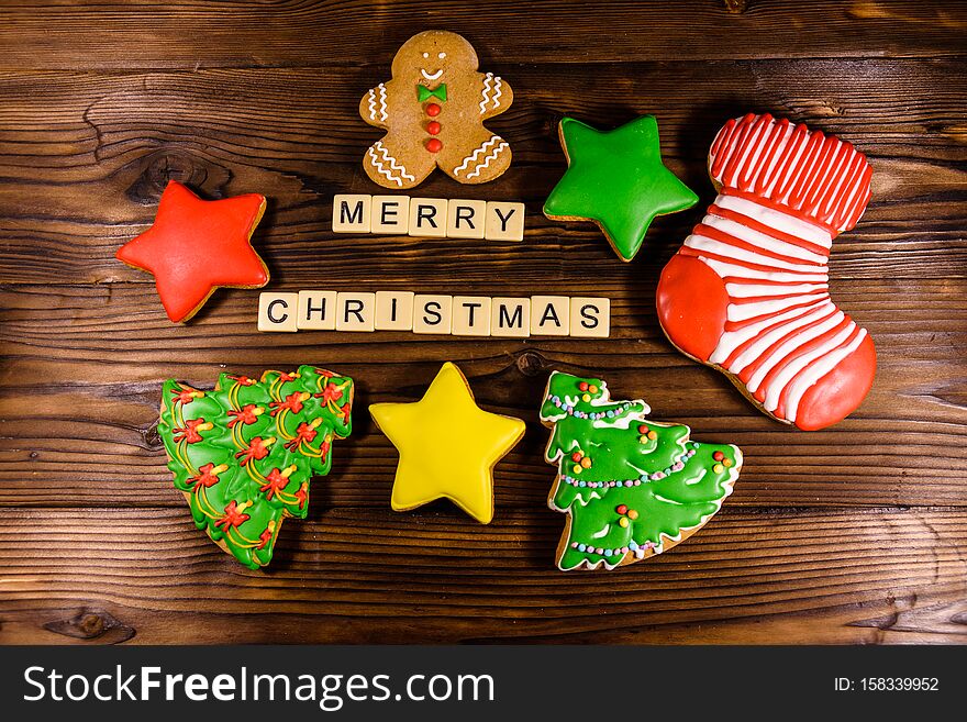 Different christmas gingerbread cookies on rustic wooden table. Top view. Merry Cristmas inscription