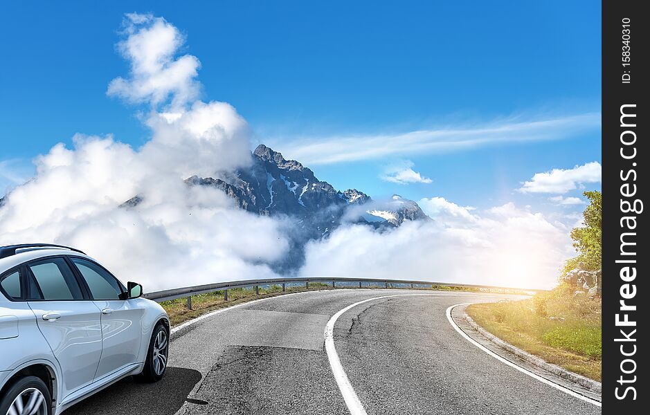 Car Moves On The Road Among The Mountains And Forests.