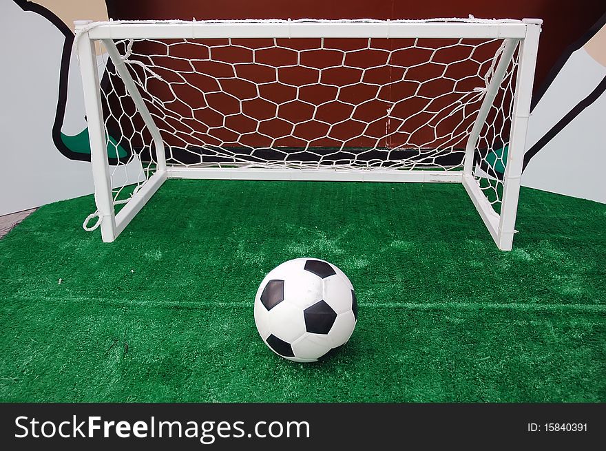 Soccer ball against the goal net in the grass. See more soccer photos in my portfoli. Soccer ball against the goal net in the grass. See more soccer photos in my portfoli