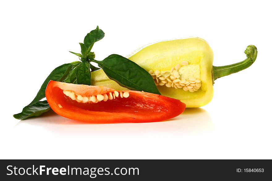 Red and yellow cut pepper and green leaf isolated on white background