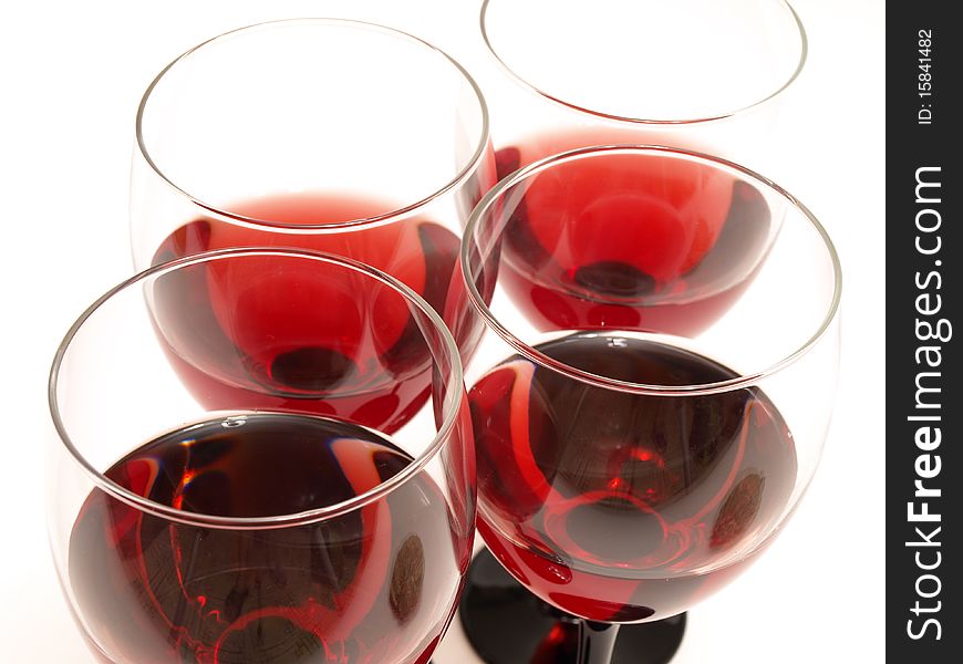 Big glass and bottle of red wine over red background. Big glass and bottle of red wine over red background