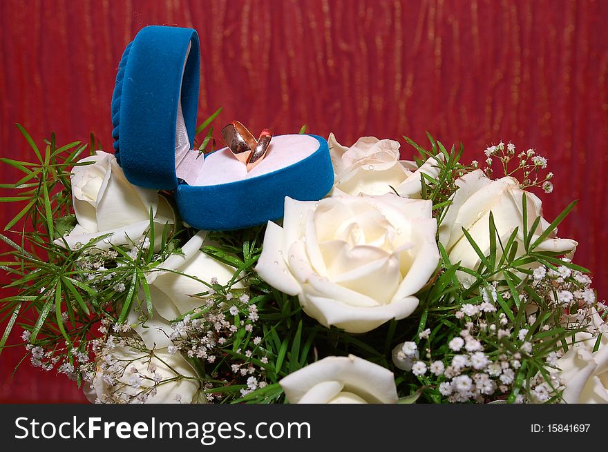 Wedding rings in blue box and rose