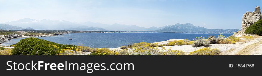 Panoramic view of castle ruin in Corsica with mountains and sea in background. Panoramic view of castle ruin in Corsica with mountains and sea in background