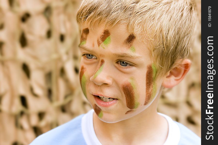 A young boy with camouflage paint on his face