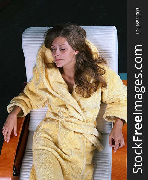 Young female in bathrobe having rest in the chaise longue. Young female in bathrobe having rest in the chaise longue