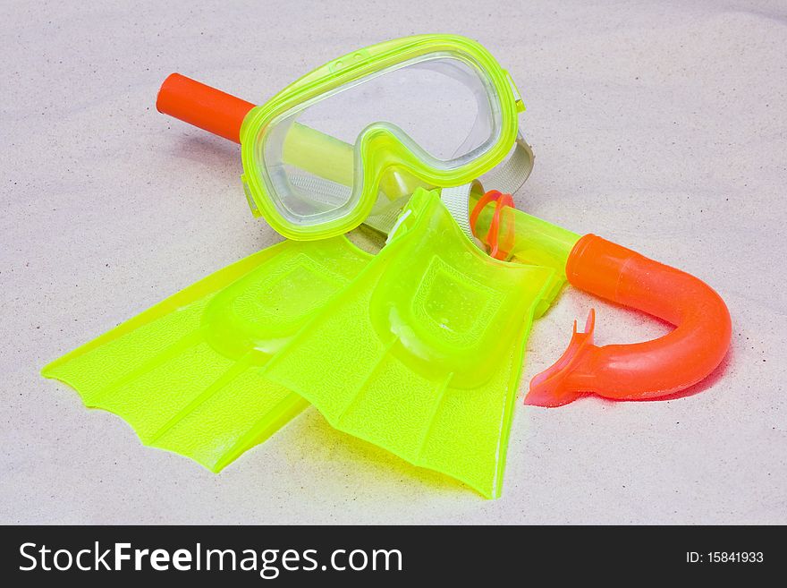 A child's snorkel, mask and flippers laying on the sand. A child's snorkel, mask and flippers laying on the sand