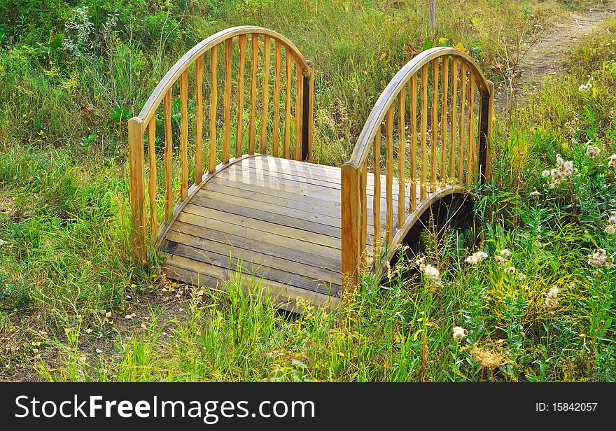 Decorative wooden bridge across a dried-up creek. Decorative wooden bridge across a dried-up creek