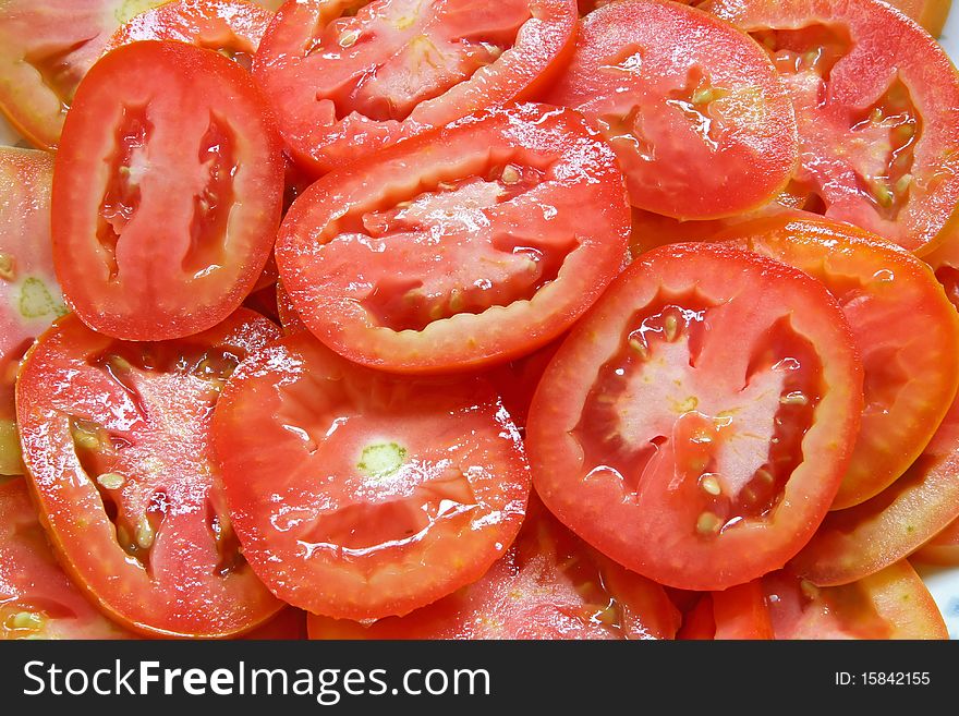 Red Sliced tomatoes on plate with water drops