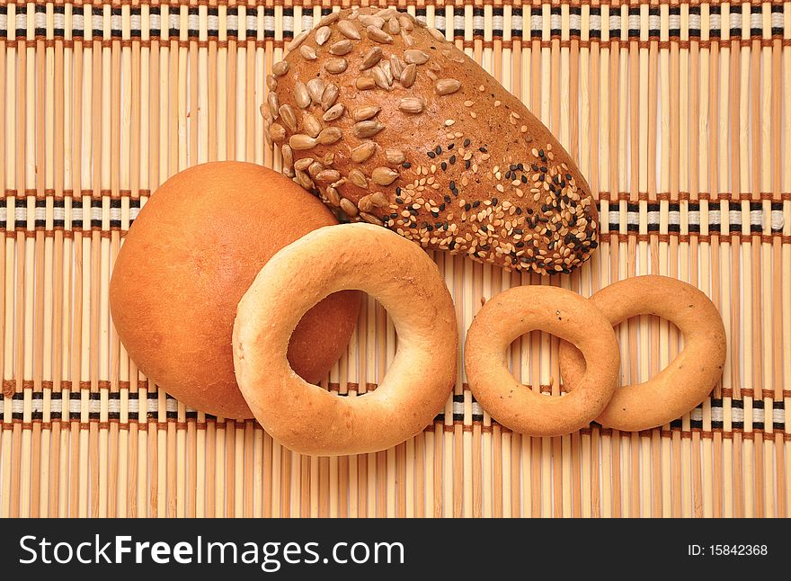 Fresh bread rolls on a straw background