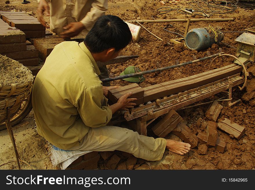 This man is to install the machine to make bricks. A funnel with a worm-filled clay produces a linear cut regularly produced bricks