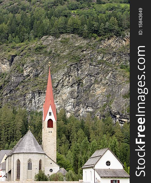 A typical mountain church in Tyrol, flanked by rock.