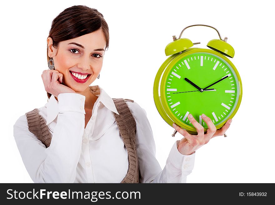 Portrait of lady holding alarm clock with one hand and one hand on chin against white background