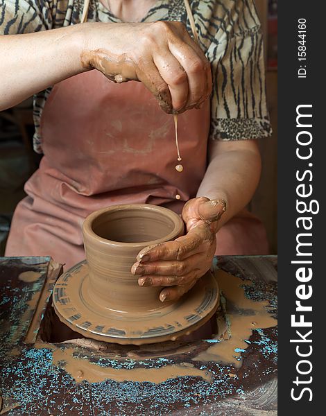 The hands of a potter, creating an earthen jar on the circle, close-ups. The hands of a potter, creating an earthen jar on the circle, close-ups