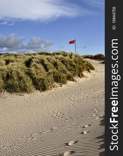 A red warning flag on a sandy beach. A red warning flag on a sandy beach