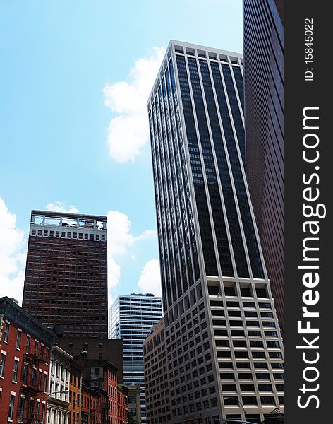 Glassy skyscrapers of Manhattan are photographed from below against blue sky. Glassy skyscrapers of Manhattan are photographed from below against blue sky.