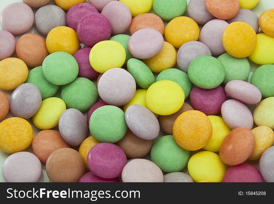 Multi color candy on white dish close up