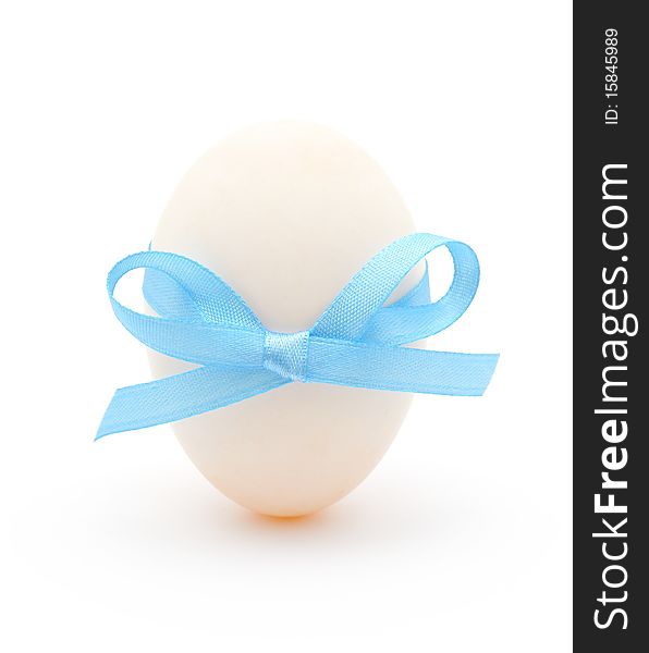 White egg wrapped around with blue ribbon over white background. White egg wrapped around with blue ribbon over white background