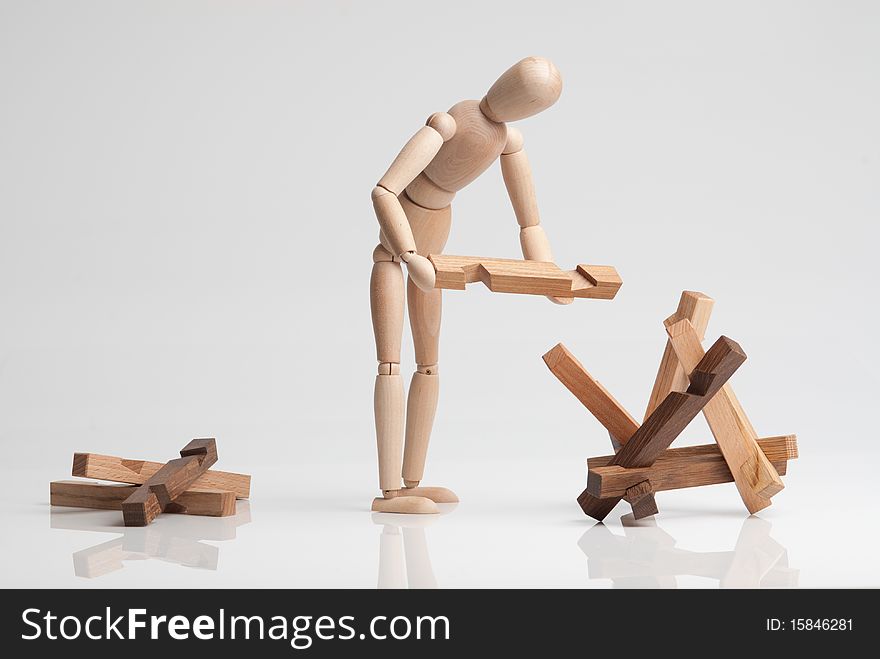 Wooden man figure trying to complete construction teaser. Wooden man figure trying to complete construction teaser.