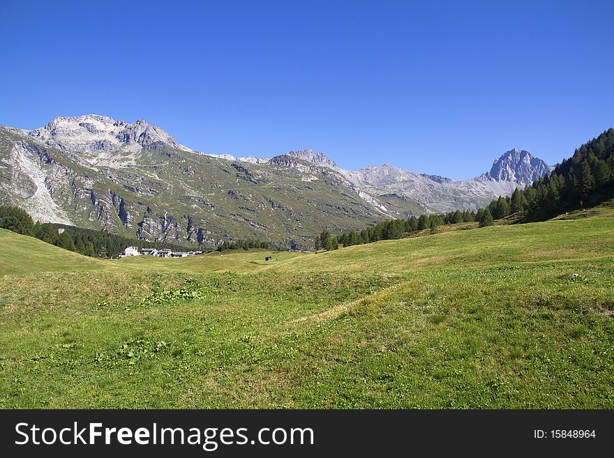 Swiss landscape with green meadows and high peaks