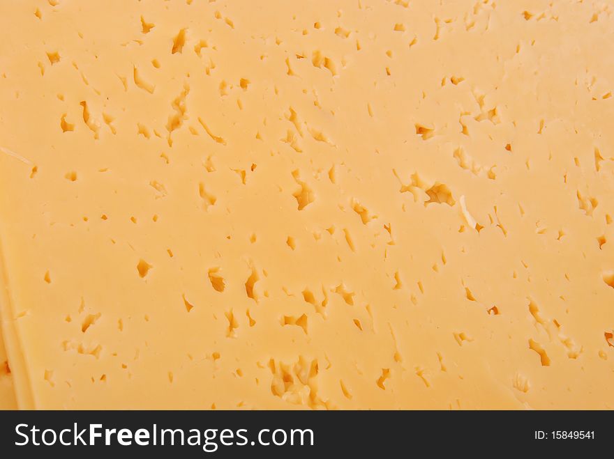 Pieces of yellow cheese as background