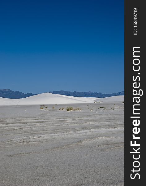 A lone white sand dune in a vast desert. A lone white sand dune in a vast desert