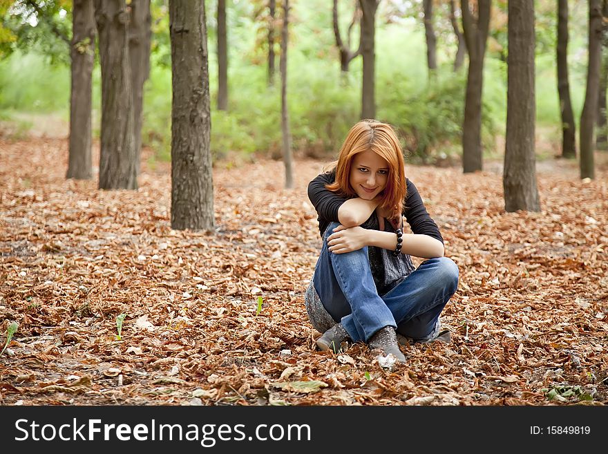 Beautiful red-haired girl in autumn park