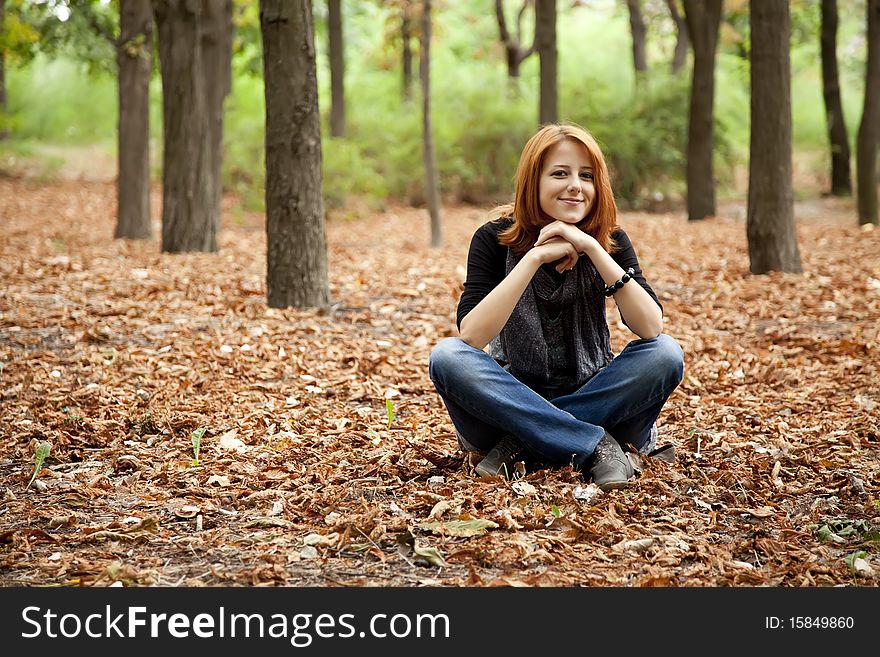 Beautiful red-haired girl in autumn park