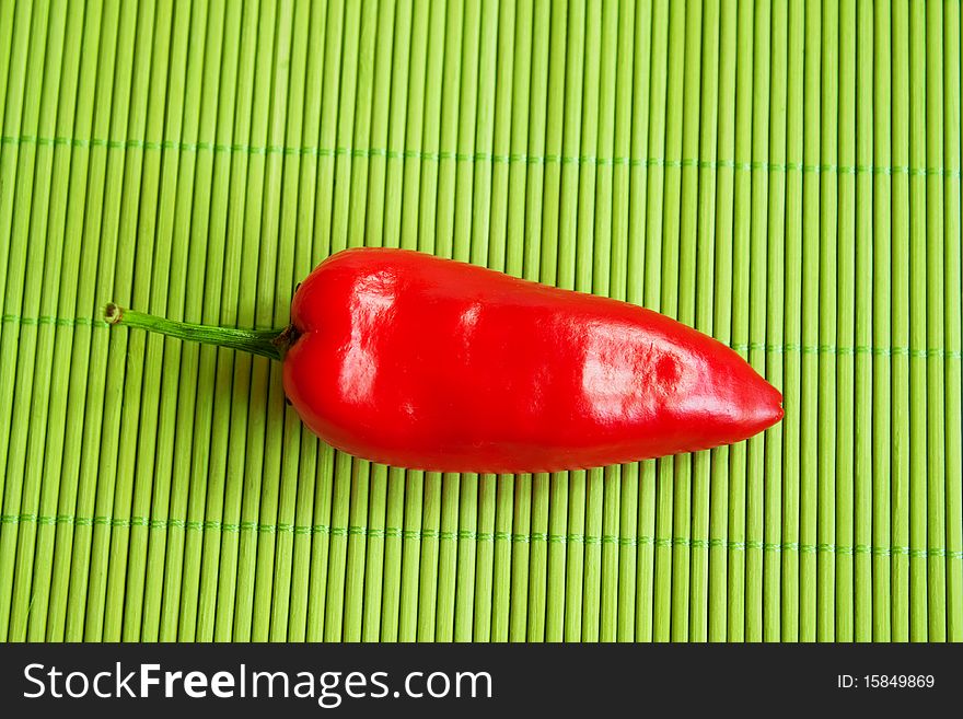 Red, hot, chilli pepper on green background for a nice dinner. Red, hot, chilli pepper on green background for a nice dinner