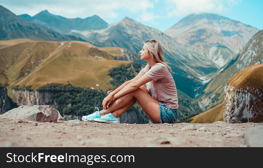 Woman hiking in mountains at sunny day time