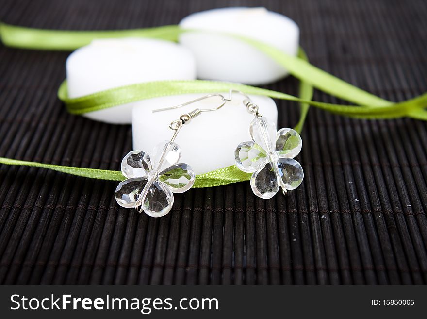 White candles on black background with earrings. White candles on black background with earrings