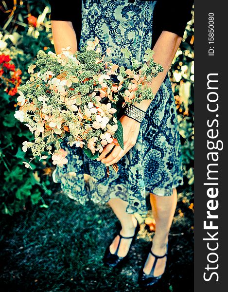 Girl in summer dress holding homemade flower bouquet; trendy colors; angle two. Girl in summer dress holding homemade flower bouquet; trendy colors; angle two