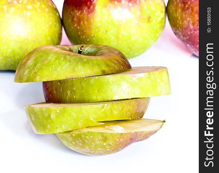 Fresh apple slices and apples in background, isolated on white