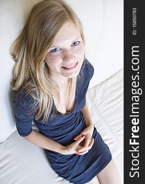 Top-to-bottom view of a cute girl sitting on the couch. Top-to-bottom view of a cute girl sitting on the couch