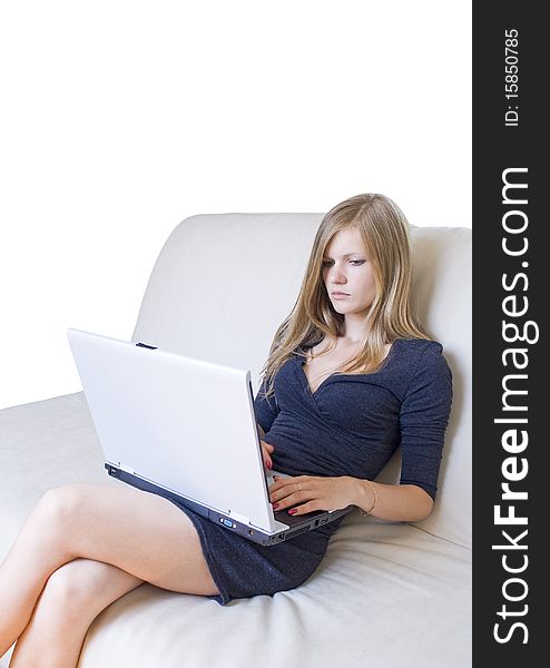 Young serious girl sitting on couch with laptop