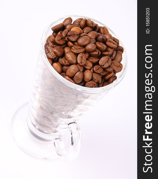 Glass of coffee beans on white background