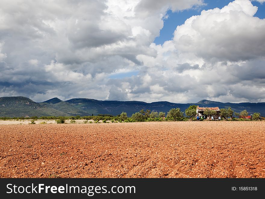 Rural landscape with field,mountain and little house