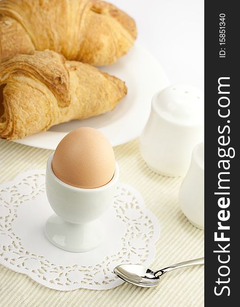 Breakfast table with egg and croissant