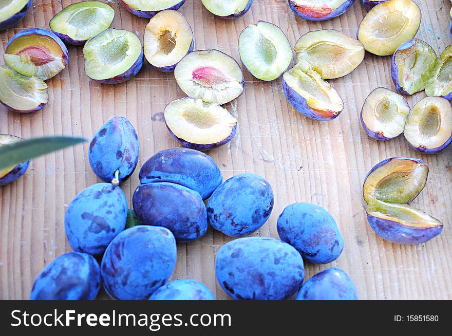 Ripe plums on wooden plate