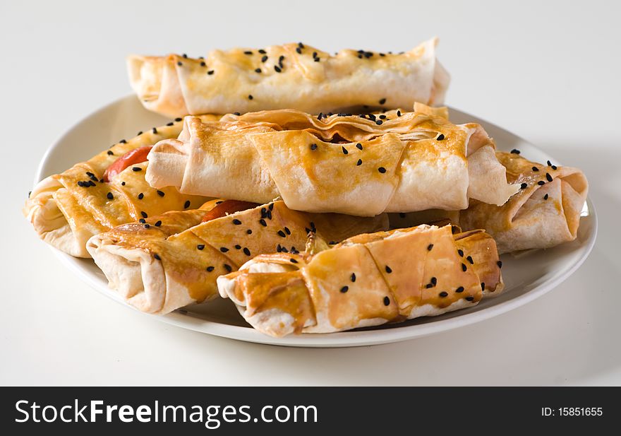 Scone with sesame seeds on a white plate.