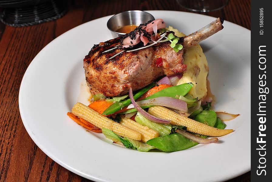 Pork Chop served on a Plate with Vegetables