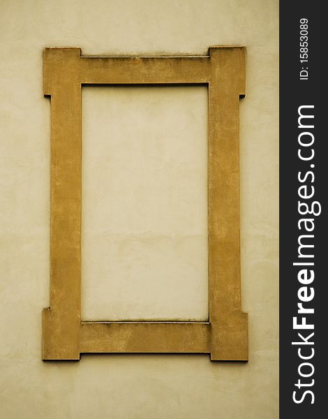 A rectangular frame made of stone in a deep yellow or gold color, on a yellow wall in Italy. Blank space for copy. A rectangular frame made of stone in a deep yellow or gold color, on a yellow wall in Italy. Blank space for copy.