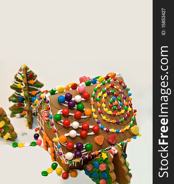 A cute gingerbread house for the holidays, colorfully decorated with candy and frosting. Copy space at the top of the image. A cute gingerbread house for the holidays, colorfully decorated with candy and frosting. Copy space at the top of the image.